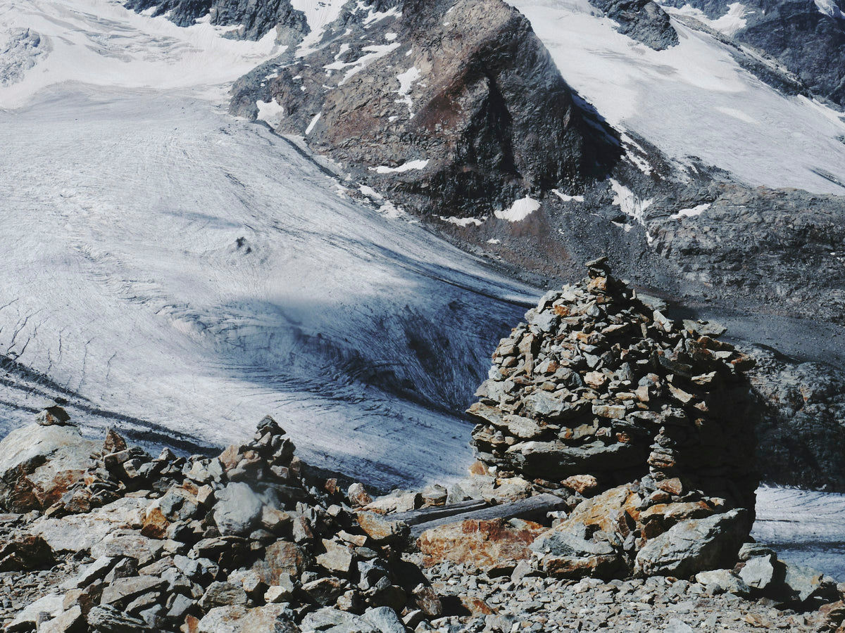 Stone cairns marking a snowy mountain trail